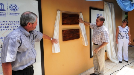 Mr Michel (centre) unveils the plaque to officially open the centre. Also in the picture are Mr Loustau-Lalanne and Mrs Dogley