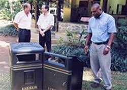 Minister Joel Morgan accepting a donation of new trash bins for Victoria.