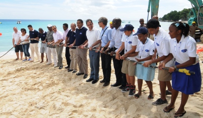 Description: President Michel and other dignitaries, company representatives and school children symbolically pulling the cable towards the shore near Beau Vallon’s La Plage restaurant 