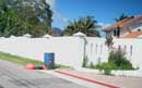 Overflowed trash can next to a luxurious house